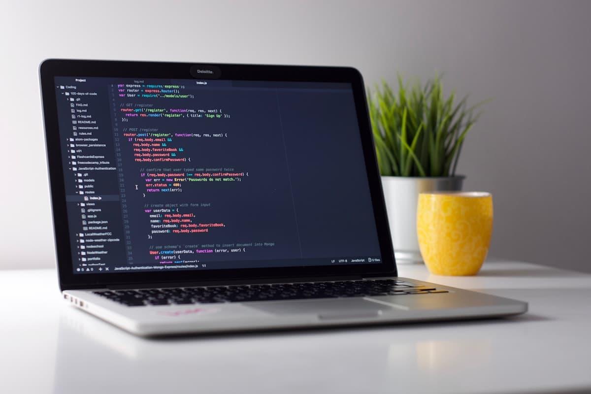Developer laptop with code on screen in a workspace