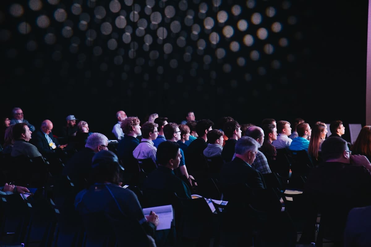 Large conference hall with audience facing a stage