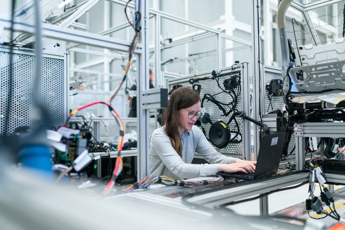 Industrial technician inspecting machinery and metal parts in a factory